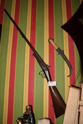 un pistolet et un couteau posés sur une étagère dans une pièce