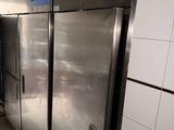 des réfrigérateurs en acier inoxydable dans une cuisine professionnelle dotée d'un sol carrelé