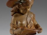 statue d'une femme lisant un livre, coiffée d'un chapeau