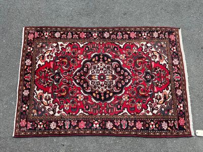 un tapis oriental posé par terre à côté d'une paire de chaussures