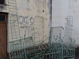 a pile of chairs and ladders in front of a building