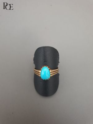 un gros plan d'une bague sertie d'une pierre turquoise