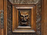 une porte en bois ornée d'une sculpture représentant un lion