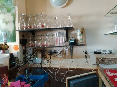 une cuisine avec de nombreux verres à vin sur les étagères