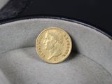 une pièce d'or posée dans une boîte sur une surface noire