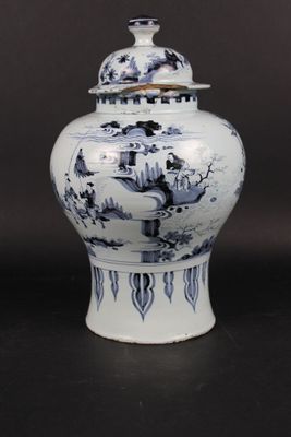 a blue and white vase with a lid sitting on a table