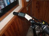 a close up of a bicycle handlebar with a bottle of water in the background
