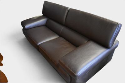 un canapé en cuir noir posé sur une surface blanche