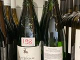 plusieurs bouteilles de vin sont alignées sur une étagère dans un magasin