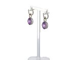 earrings with amethorate and diamonds on a stand on a white background