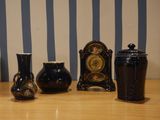 three vases and a clock sitting on a table