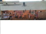 a picture of a workbench with many tools hanging on it