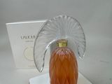 a bottle of perfume on a white plate with a box in the background