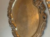 two silver plates and a silver spoon on a table