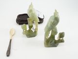 deux figurines vertes posées à côté d'une cuillère et d'un repose-cuillère