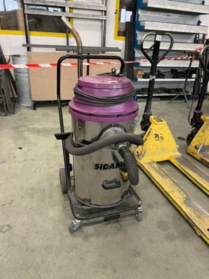 un aspirateur violet posé sur une palette dans un entrepôt