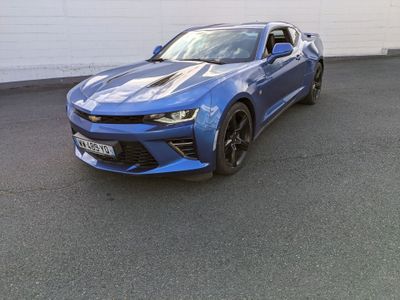 La Chevrolet Camaro est garée devant un mur blanc.