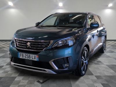 la voiture bleue est garée sur un sol en damier dans le garage