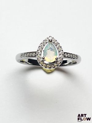 une bague en opale blanche et diamants, avec une pierre centrale en forme de poire