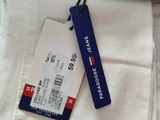 a tag on the back of a pair of white pants