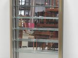 a glass display case with a mirror on the wall