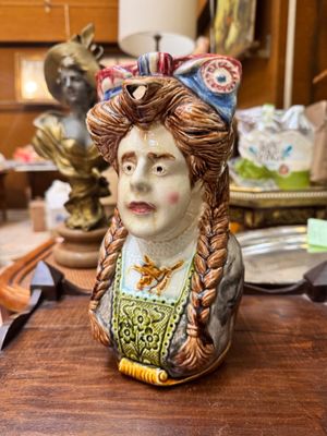 un buste en céramique représentant une femme, posé sur une table