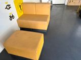 a couch and ottoman in a room with a yellow sign