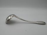une cuillère en argent avec un manche de cuillère sur une surface blanche