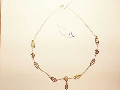gold necklace with a long chain and a pendant with a bird on it