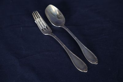 deux cuillères et une fourchette posées sur une nappe bleue