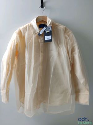 une chemise blanche suspendue à un cintre sur un mur