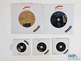four cd ' s on a white surface with labels on them
