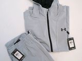 the under armour jacket and pants are set up on a white surface