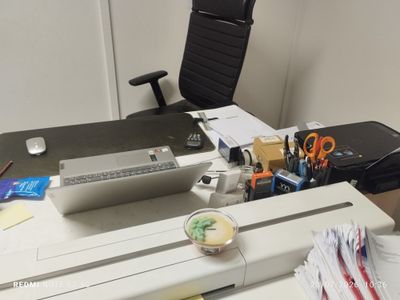un bureau sur lequel se trouvent un ordinateur portable, une imprimante et d'autres fournitures de bureau