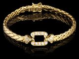 un gros plan d'un bracelet en or serti de diamants sur fond noir