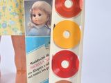 a doll that is standing next to a box of doughnuts