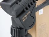 a close up of a tripod with a box in the background