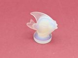 un poisson en plastique posé sur une surface rose