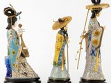 three asian figurines of women with hats and holding umbrellas