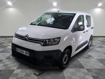 la camionnette blanche est garée sur un sol en damier dans le garage