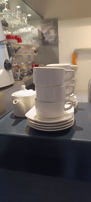 une pile de tasses et de soucoupes posée sur un comptoir