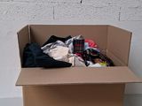 a cardboard box with clothes in it sitting on a table