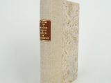 un vieux livre posé sur une table blanche à côté d'un mur blanc
