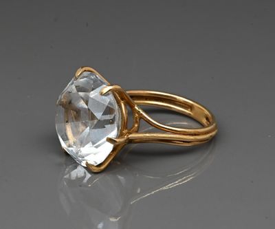 a close up of a gold ring with a clear crystal stone