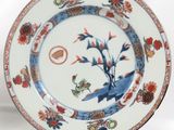 a blue and white plate with a bird and flowers on it