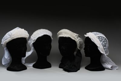 trois têtes de mannequins noires coiffées de chapeaux blancs