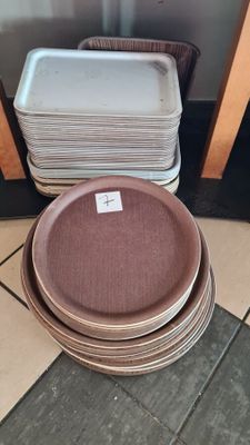 a stack of plates sitting on the floor next to a stack of pans