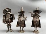 three figurines of a man and a woman playing instruments