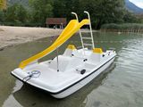 a white boat with a yellow slide in the water