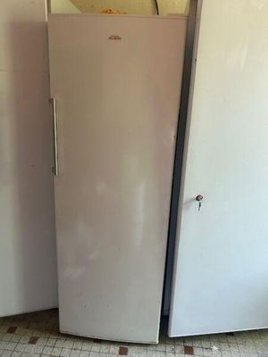 two refrigerators in the corner of a room